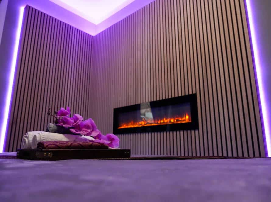 Stimmungsvoller Massageraum bei Milanee Thaimassage mit warmem Licht, Orchideen und entspannter Atmosphäre für Thai Massage in Nürnberg.