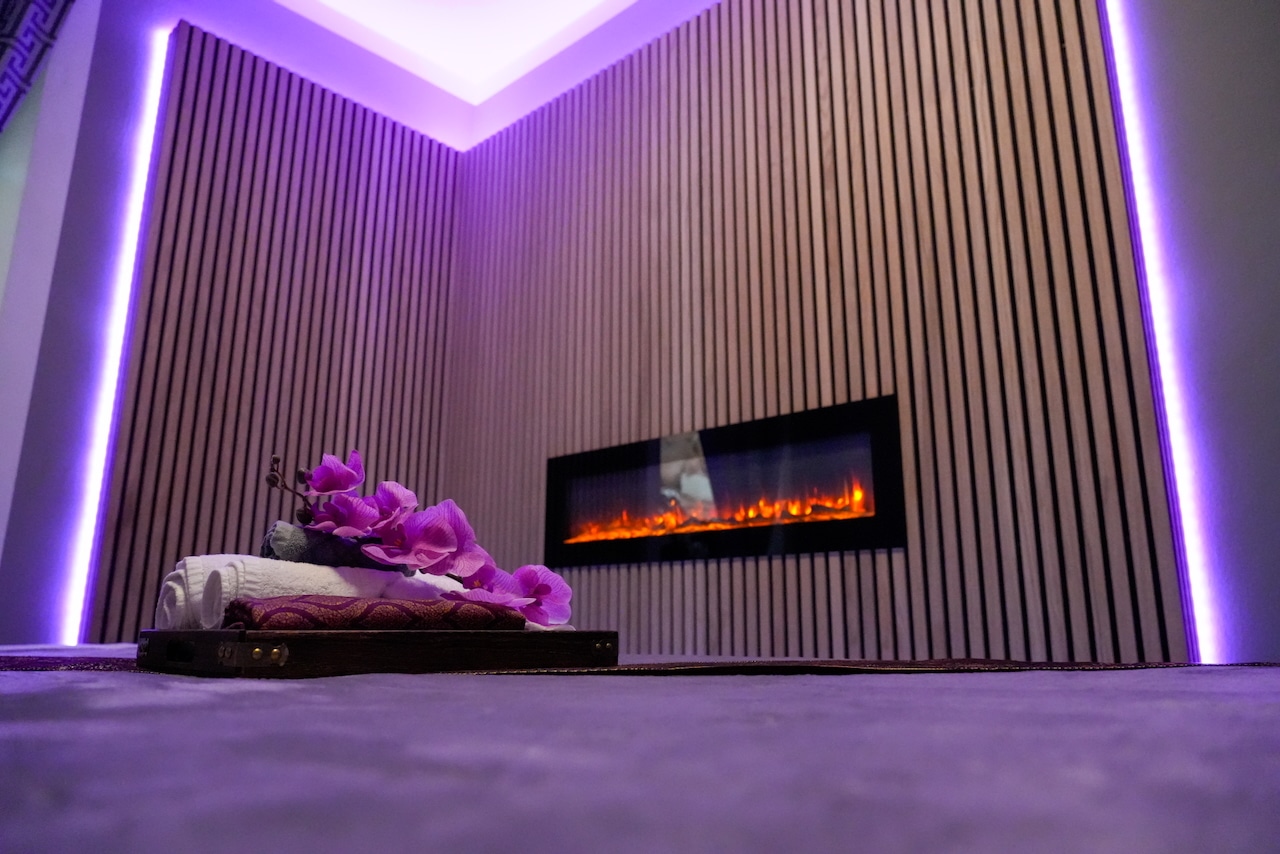 Stimmungsvoller Massageraum bei Milanee Thaimassage mit warmem Licht, Orchideen und entspannter Atmosphäre für Thai Massage in Nürnberg.